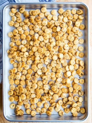 Seasoned oyster crackers on a baking pan.