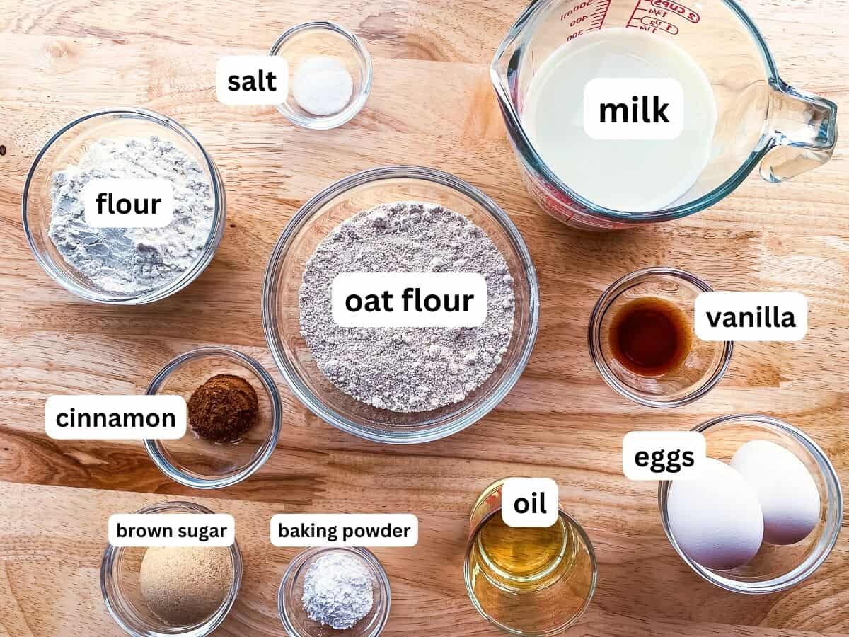 All the ingredients for oat flour pancakes on a counter in individual bowls.