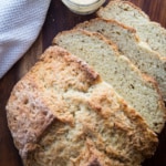 Caraway Irish soda bread sliced on a cutting board with a small jar of butter next to it.
