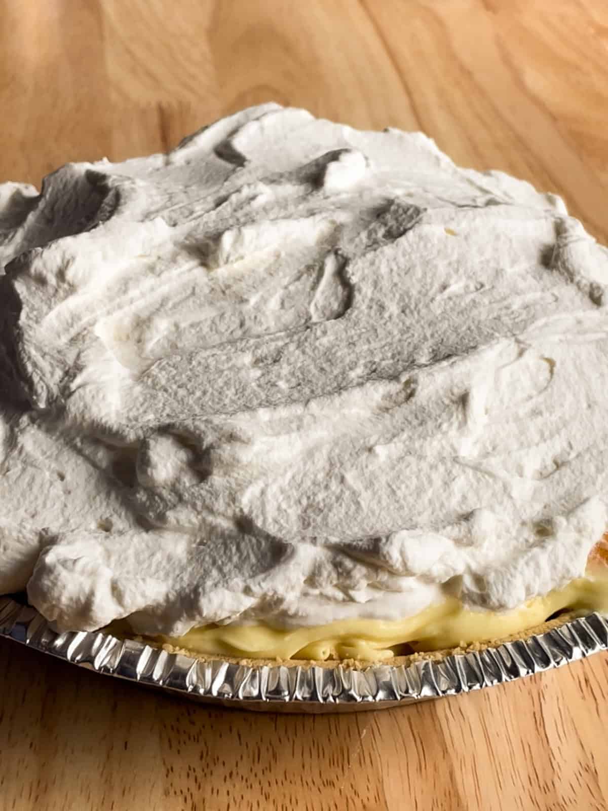 Banana pudding pie topped with a layer of whipped cream.
