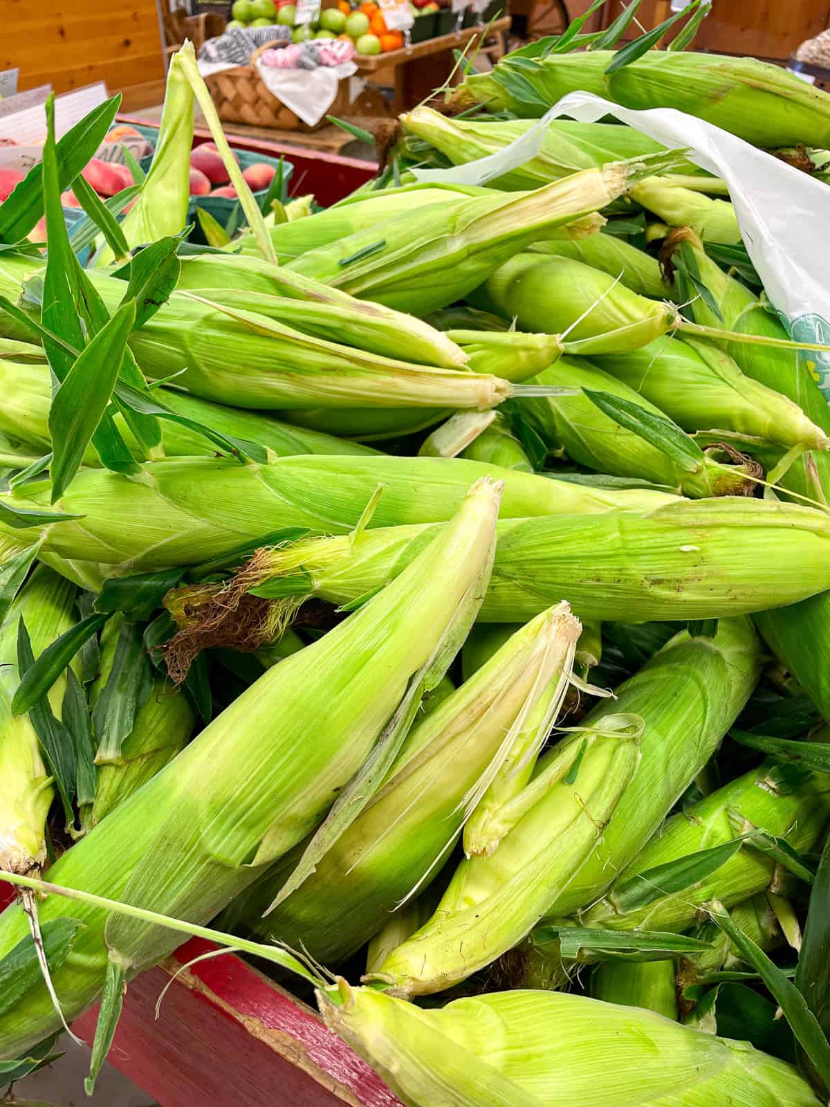 A pile of fresh corn at a farm market.