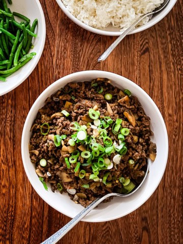 Korean BBQ-style ground beef bowl topped with sliced green onions.