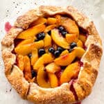 A peach-blueberry galette on parchment paper.