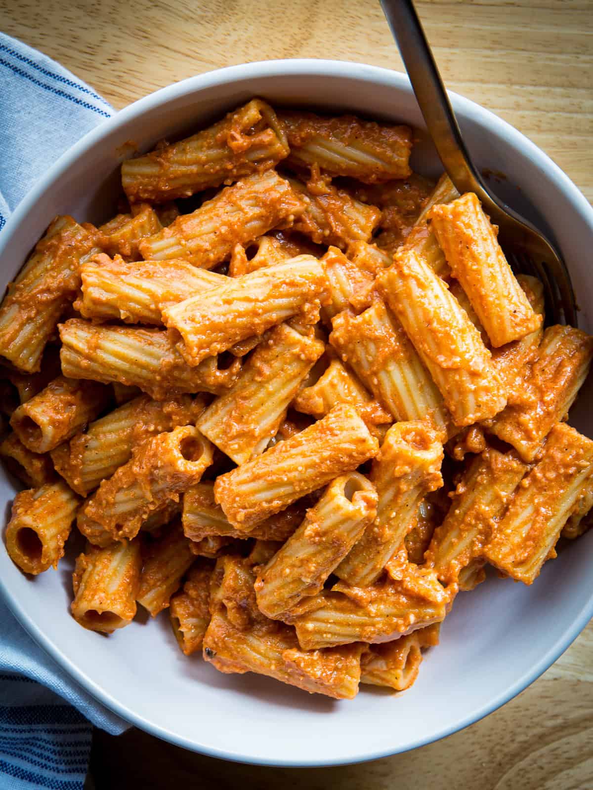 A bowl of pasta with tomato cream sauce.