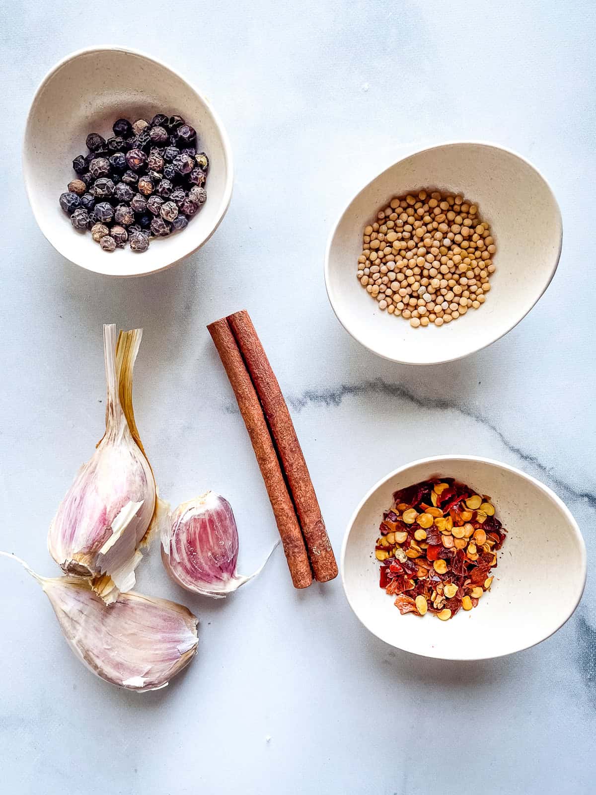 Seasonings for pickled red onions in individual bowls and on the counter.