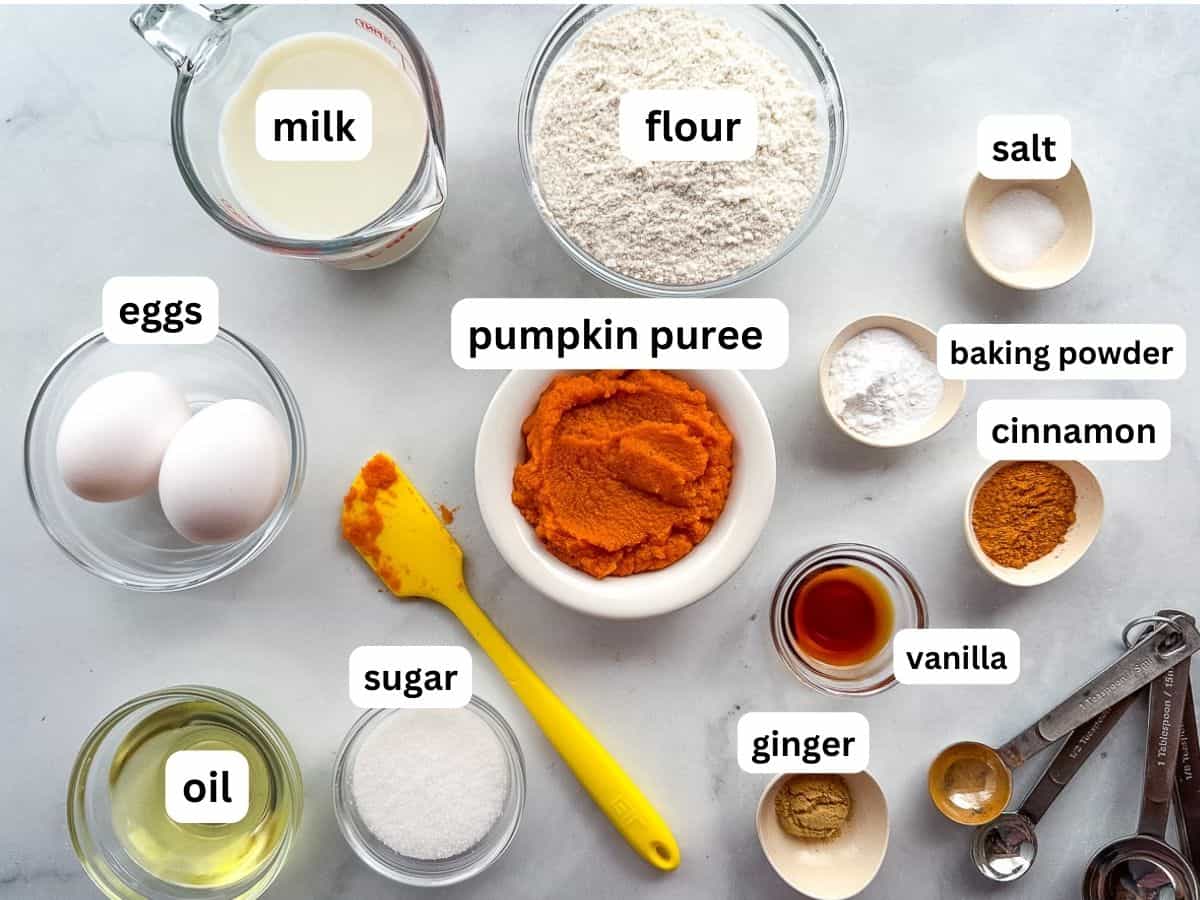 Ingredients for pumpkin pancakes in bowls on the counter.