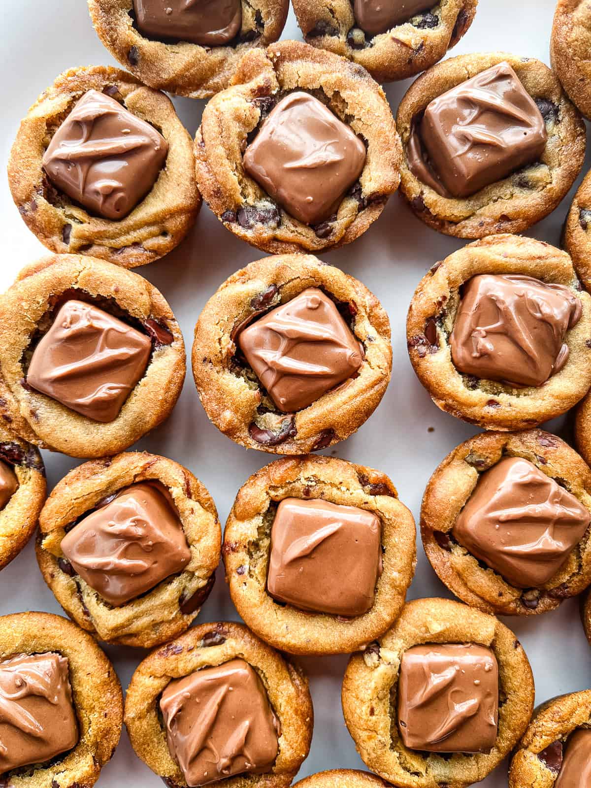 Snickers chocolate chip cookie cups on a plate.