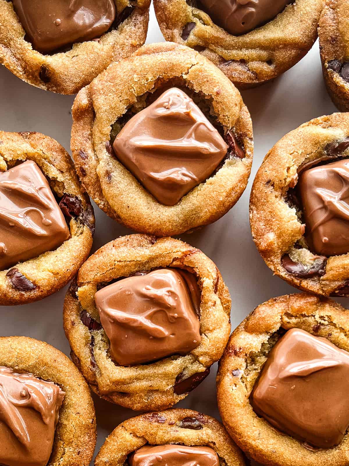 Snickers chocolate chip cookie cups on a plate.