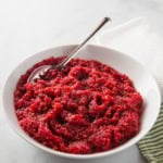A bowl of cranberry orange relish with a spoon.