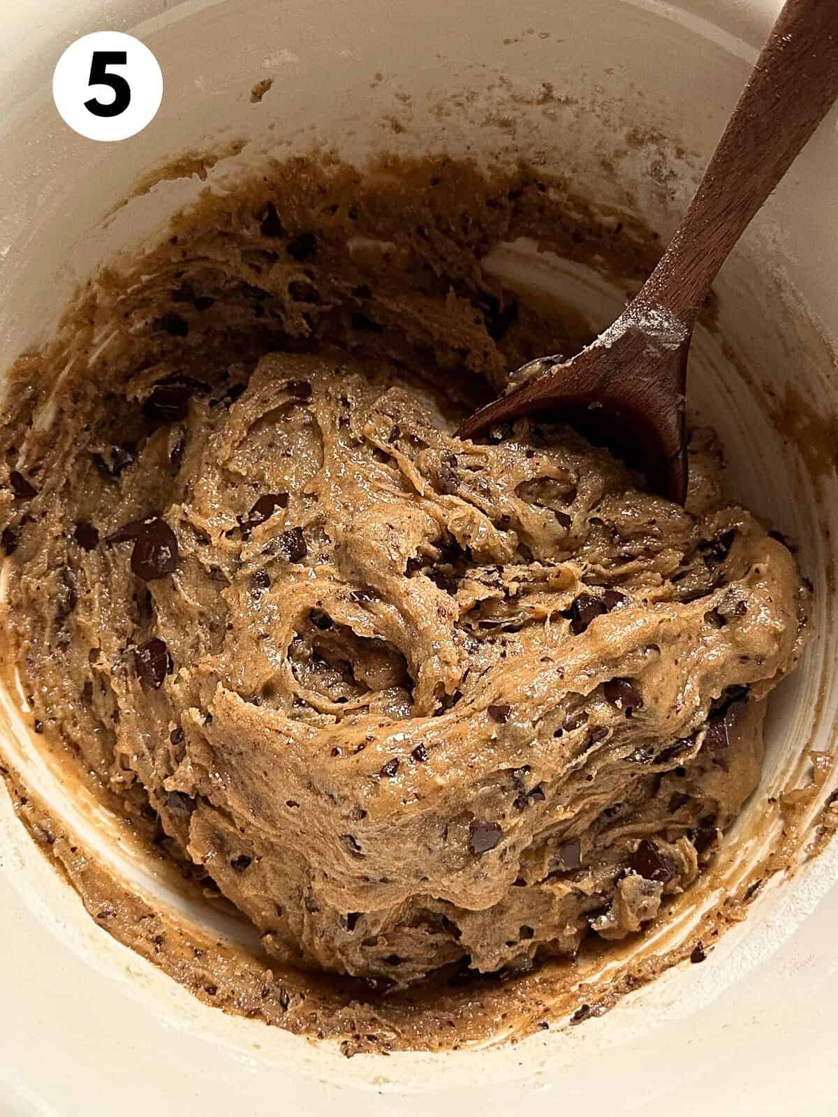 Bowl of thin chocolate chip dough with the chopped chocolate mixed into the dough.