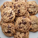 Thin chocolate chip cookies sitting on a plate.