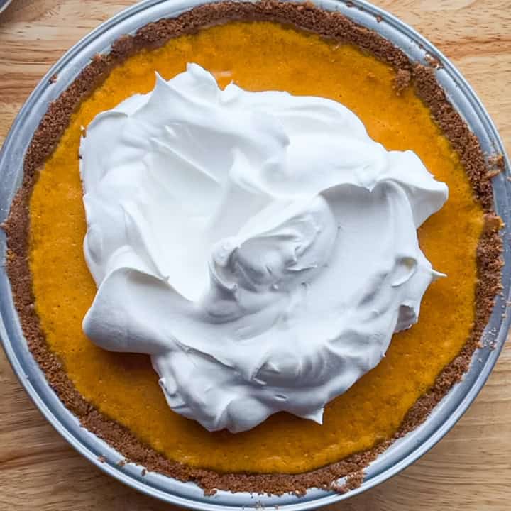 Pumpkin cheesecake pie with a gingersnap crust topped with whipped cream